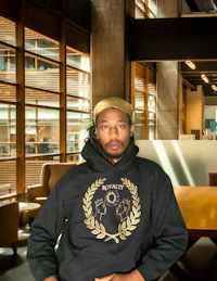 a man wearing a hoodie sitting at a table